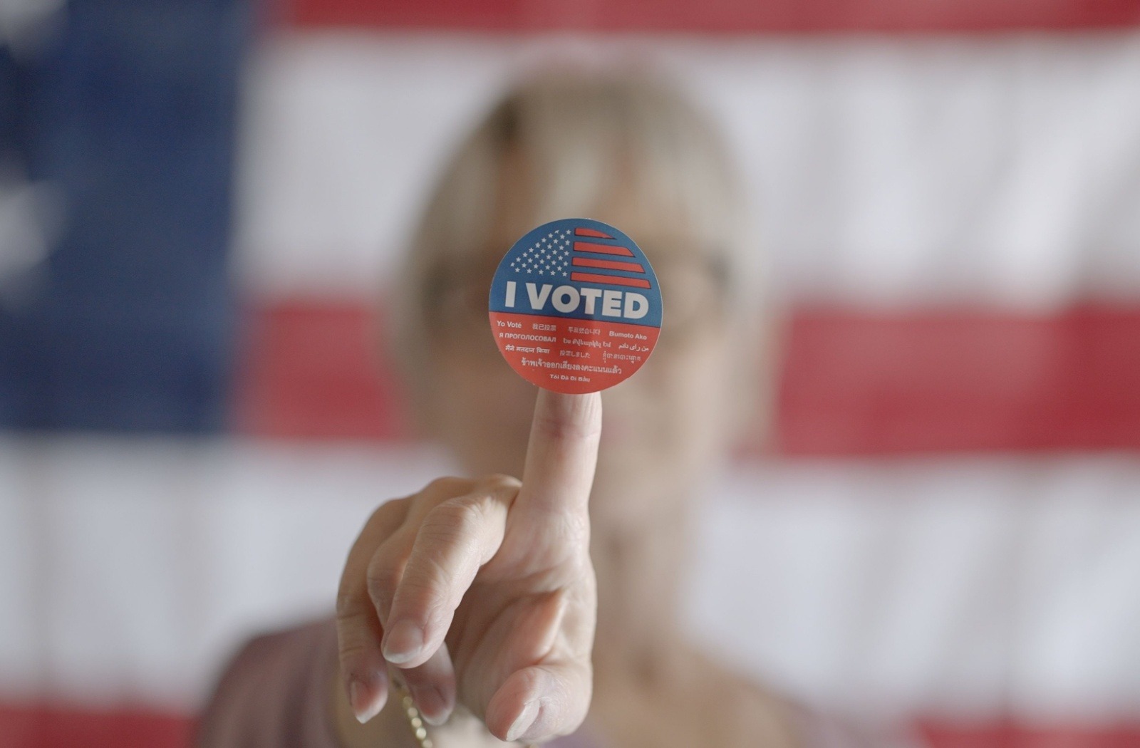 A close-up of a senior holding an "I voted" sticker.
